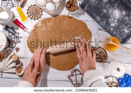 Cooking baking Halloween gingerbread cookies. Preparing for Halloween party holiday, mom and child cook together, make cut homemade funny cookies with molds in form of holiday symbols and monsters 
