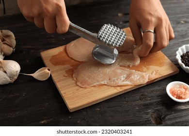 Cooking Breast Chicken Meat, Female Hand Beat Chicken using Meat Tenderizer. Cooking Process in The Kitchen.  - Powered by Shutterstock