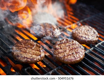 cooking burgers on hot grill with flames
