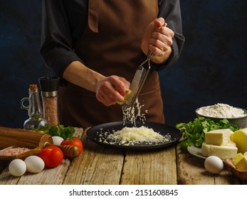 Cooking with cheese. The chef grates cheese on a kitchen wooden table. Lots of ingredients for making salad, pizza, spaghetti, pasta. Healthy vegetarian food, healthy lifestyle. Banner. - Powered by Shutterstock