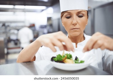 Cooking, chef and woman in restaurant serving dish for gourmet lunch, fine dining and dinner. Kitchen, catering and person with seasoning, flavor and ingredients for culinary cuisine, salad or food - Powered by Shutterstock