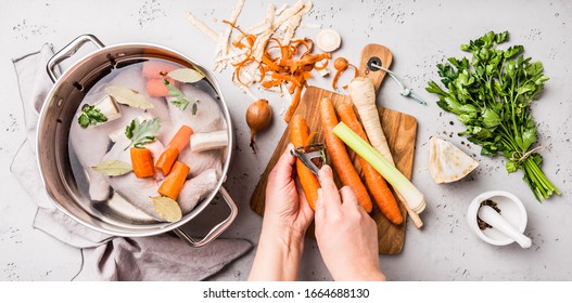 Kochen - Küchenchef Hände Vorbereitung Hühnerstock (Brot oder Bouillon) mit Gemüse in einem Topf. Küche - grauer Beton-Arbeitsszenerie von oben (Draufsicht, flache Lage).