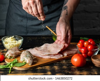 Cooking chicken filet stuffed with vegetables and cheese mozzarella by chef man hands on rustic wooden table background with ingredients. - Powered by Shutterstock