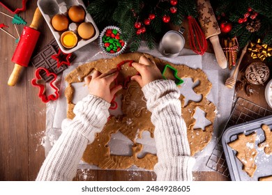 Cooking Christmas cookies family background. Mother and daughter hands top view on cozy wooden background, making gingerbread biscuits with cookie cutters, with New Year Christmas decoration - Powered by Shutterstock