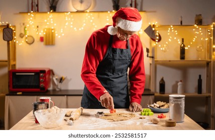 Cooking Christmas cookies. Senior man wearing Santa hat making gingerbread biscuits with cookie cutters. New Year Christmas decoration. Copy space - Powered by Shutterstock