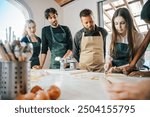 Cooking class, culinary experience of preparing ravioli, a typical Italian dish - Group of students attend the course practicing under the supervision of the chef