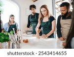 Cooking class, culinary experience of preparing fresh egg pasta, a typical Italian dish - Group of students attend the course practicing under the supervision of the chef