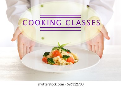 Cooking classes concept. Female chef serving plate of pasta salad on table - Powered by Shutterstock