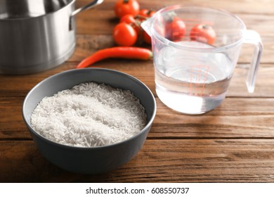 Cooking concept. Bowl with rice on kitchen table - Shutterstock ID 608550737
