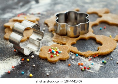 Cooking cookies with  cookie cutters on a dark table