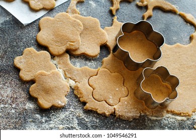 Cooking cookies with  cookie cutters on a dark table