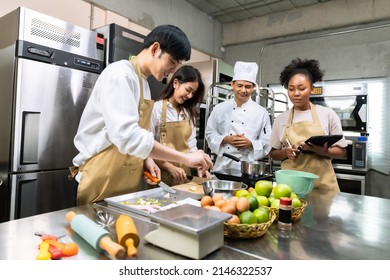 Cooking  course , senior Asian male chef in cook uniform teaches young asian and african american people cooking class students to prepare, mix ingredients for pastry foods, in restaurant stainless  - Shutterstock ID 2146322537
