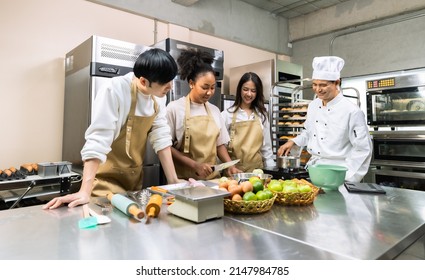 Cooking  course , senior Asian male chef in cook uniform teaches young asian and african american people cooking class students to prepare, mix ingredients for pastry foods, in restaurant stainless  - Powered by Shutterstock