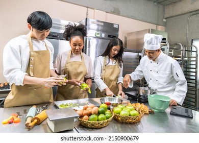 Cooking  Course , Senior Asian Male Chef In Cook Uniform Teaches Young Asian And African American People Cooking Class Students To Prepare, Mix Ingredients For Pastry Foods, In Restaurant Stainless 