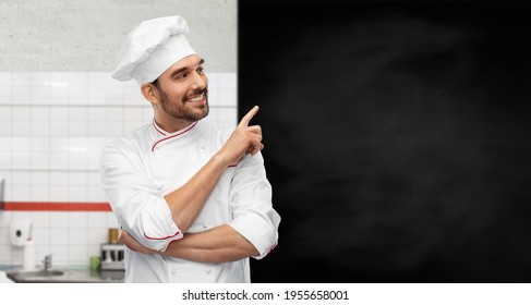 cooking, culinary and people concept - happy smiling male chef in toque with big black chalkboard white board over restaurant kitchen background - Powered by Shutterstock