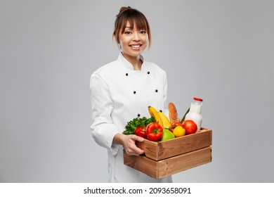 Cooking, Culinary And People Concept - Happy Smiling Female Chef In Toque Holding Food In Wooden Box Over Grey Background