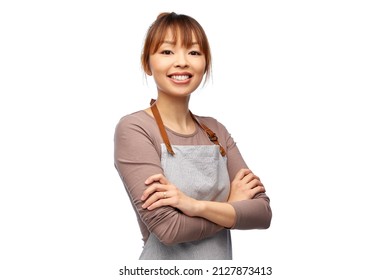 Cooking, Culinary And People Concept - Happy Smiling Female Chef Or Waitress In Apron With Crossed Arms Over White Background