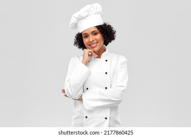 Kochen, Gastronomie- und People-Konzept - glücklicher, lächelnder Küchenchef auf weißer Seite und Jacke auf grauem Hintergrund