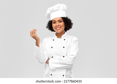 Kochen, Gastronomie- und People-Konzept - glücklicher Küchenchef in Toque-und weißer Jacke mit Gourmet-Schild auf grauem Hintergrund