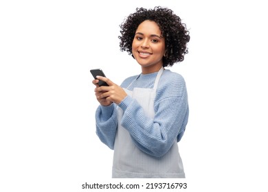 Cooking, Culinary And People Concept - Happy Smiling Woman In Apron With Smartphone Over White Background