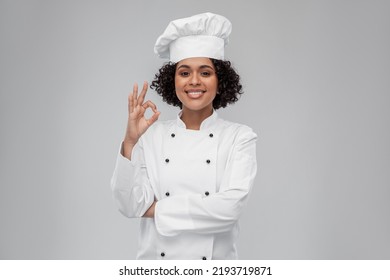 cooking, culinary and people concept - happy smiling female chef in toque showing ok hand sign over grey background - Powered by Shutterstock