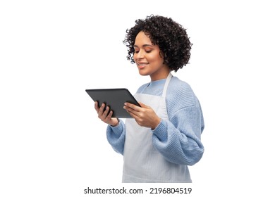 cooking, culinary and people concept - happy smiling woman in apron with tablet pc computer over white background - Powered by Shutterstock