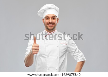 cooking, culinary and people concept - happy smiling male chef in toque showing thumbs up over grey background