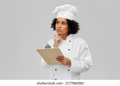 Kochen, Gastronomie- und People-Konzept - denkende Küchenchefin in weißer Toque und Jacke mit Beschneidungspfad und Stift auf grauem Hintergrund