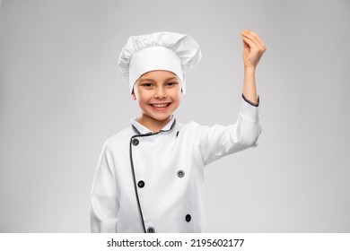 Cooking, Culinary And Profession Concept - Happy Smiling Little Boy In Chef's Toque And Jacket Over Grey Background