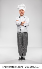 Cooking, Culinary And Profession Concept - Happy Smiling Little Boy In Chef's Toque And Jacket Over Grey Background