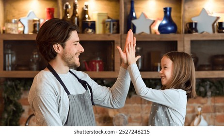 Cooking With Daddy. Happy Little Girl Giving High Five To Her Father After Preparing Lunch Together, Bonding In Kitchen, Side View - Powered by Shutterstock