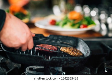 Cooking Dinner In A Restaurant. Close-up Of A Chef’s Hand Frying Vegan Burger 