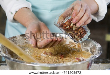 Cooking dough for the pie in the kitchen. In the photo, women's hands knead the dough.
