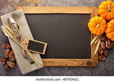 Cooking and eating in fall season, forks and spoon in a rustic autumn table setting with chalkboard copyspace