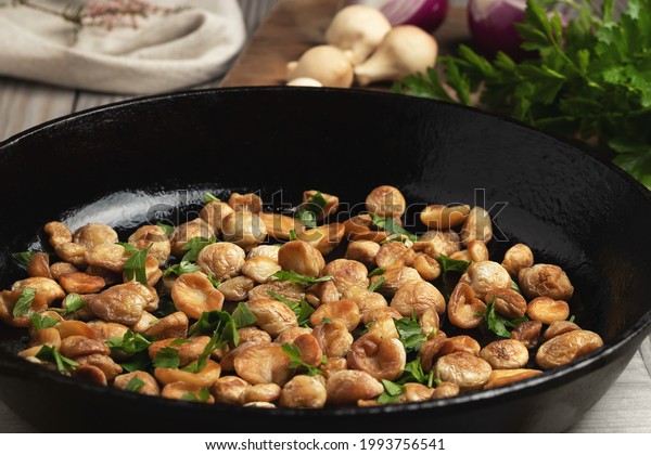 Cooking edible puffball mushrooms. Fried mushrooms in\
a cast iron pan