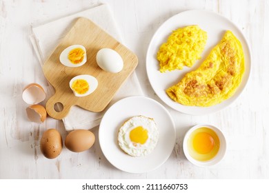 Cooking eggs in deferent way like boiled egg, fried egg and scrambled egg on wooden table. Top view.