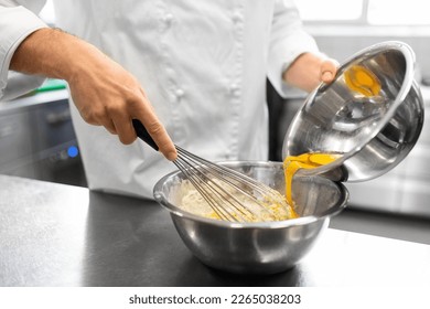 cooking food, baking and people concept - close up of male chef cook whipping dough or batter by whisk in bowl at restaurant or bakery kitchen - Powered by Shutterstock