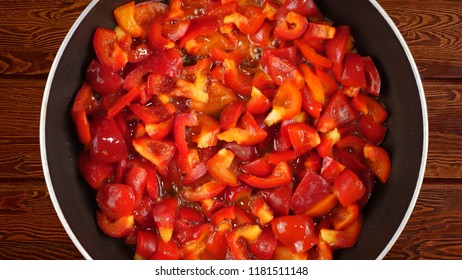 Cooking Food Concept. The Cook Fries A Red Sweet Bulgarian Pepper In A Frying Pan. Kind Of The First Perspective, The Point Of View Of The Chef Person.