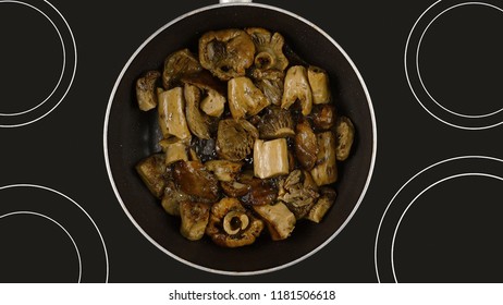 Cooking Food Concept. Cook Fry The Mushrooms In A Frying Pan. Kind Of The First Perspective, The Point Of View Of The Chef Person. Glass-ceramic Radiant Hob As Background.