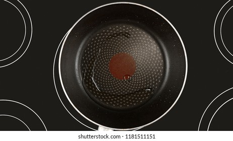 Cooking Food Concept. Olive Or Sunflower Oil On A Hot Frying Pan. Kind Of The First Perspective, The Point Of View Of The Chef Person. Glass-ceramic Radiant Hob As Background.