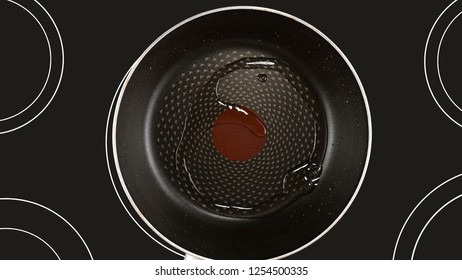 Cooking Food Concept. Olive Or Sunflower Oil On A Hot Frying Pan. Kind Of The First Perspective, The Point Of View Of The Chef Person. Glass-ceramic Radiant Hob As Background. High Quality Photo. 