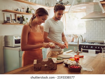 Cooking food, happy and healthy couple preparing a dinner meal in the kitchen together at home. Excited, carefree and joyful lovers doing smiling and laughing while making food or lunch - Powered by Shutterstock