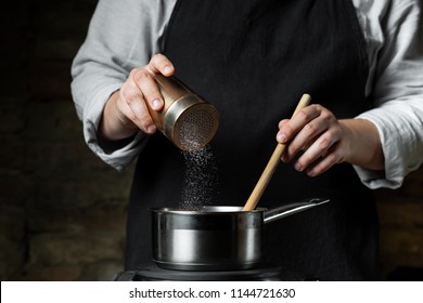 Cooking Food In Metal Saucepan, Adding Salt By Chef Hands. Food Concept Background.