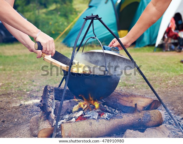 Cooking food over campfire in\
hike