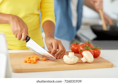 Cooking, Food And People Concept - Close Up Of African Woman Hands With Knife Chopping Vegetables On Cutting Board