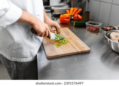 cooking food, profession and people concept - close up of male chef with knife chopping celery on cutting board at restaurant kitchen - Powered by Shutterstock