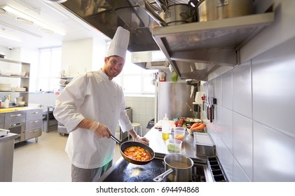 cuisine, profession et concept de personnes - chef masculin heureux cuisinier avec du pot et de la poêle à la cuisine du restaurant