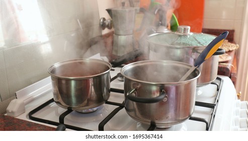 Cooking food, steam coming out from pans and pots.