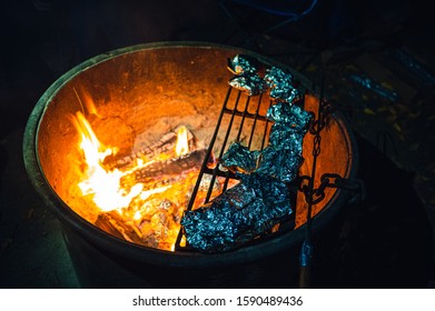 Cooking Food In Tin Foil Over Fire At Campground