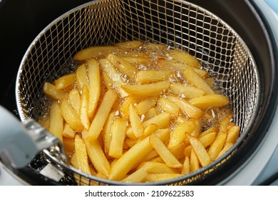Cooking fried potatoes in deep fryer - Shutterstock ID 2109622583